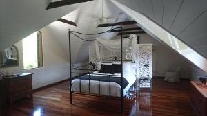 ein Schlafzimmer mit einem Himmelbett im Dachgeschoss in der Unterkunft The Barn in Bangalow