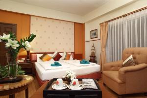 a hotel room with two beds and a chair at People Place Classic Hotel SHA Extra Plus in Chiang Mai +65 photos