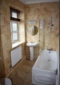 bagno con lavandino, servizi igienici e lavandino di Rettendon Lodge a Battlesbridge