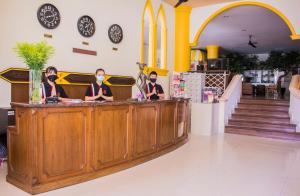 a group of people standing at a counter in a store at People Place Classic Hotel SHA Extra Plus in Chiang Mai