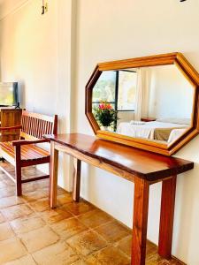 a mirror on a table in a room with a bed at Hotel Cordelia's in Puerto &Aacute;ngel