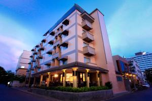 a large pink building with balconies on a street at People Place Classic Hotel SHA Extra Plus in Chiang Mai