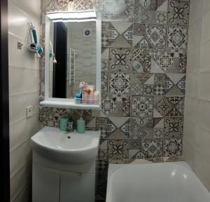 a bathroom with a sink and a toilet and a mirror at АpartmentAnna in Odesa +14 photos