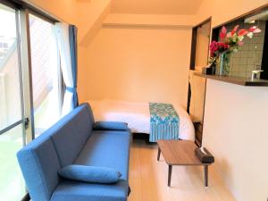 ein kleines Zimmer mit einem Sofa und einem Bett in der Unterkunft COCOSTAY Matoba ココステイ マトバ in Hiroshima