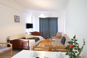 DebbieXenia Hotel Apartments في بروتاراس: غرفة بسرير وكراسي وطاولة