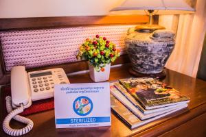 a desk with a phone and a book and a lamp at People Place Boutique In Town Hotel - SHA Extra Plus in Chiang Mai