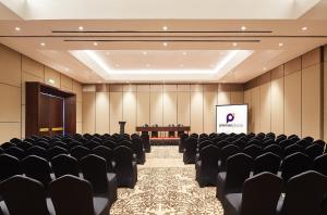诗都阿佐Premier Place Surabaya Airport的一间配有黑色椅子和屏幕的会议室 更多37张照片