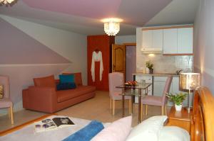 a living room and kitchen with a couch and a table at Alkyoni Apartments & Studios in Poros