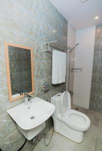 a bathroom with a white toilet and a sink at Soi Suites in Talibon