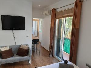 a room with a tv and a couch and a table at New Apartment & Parking Alcazaba in Málaga