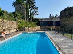una piscina azul con terraza de madera y un edificio en Maison d'hôtes & Gîtes Domaine de la Garaye, en Dinan