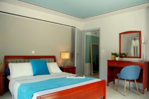 a bedroom with a bed and a mirror and a chair at Alkyoni Apartments & Studios in Poros