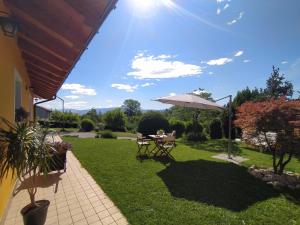 eine Terrasse mit einem Tisch und einem Sonnenschirm in der Unterkunft B&B Dolomitincanto in Cesiomaggiore