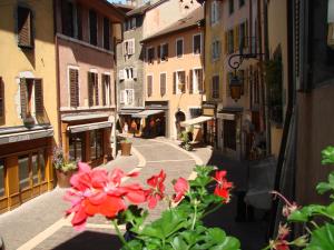 a view of a street with red flowers in a city at Icône Hôtel - Annecy in Annecy