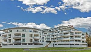 ein großes weißes Apartmenthaus mit blauem Himmel in der Unterkunft FEWO Excellence in Traben-Trarbach