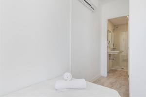 a white room with a bed and a bathroom at Hostal Talamanca in Cala d´Or