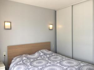 濱湖勒布爾歇的住宿－RESIDENCE DU PORT，卧室配有一张床,墙上有两盏灯