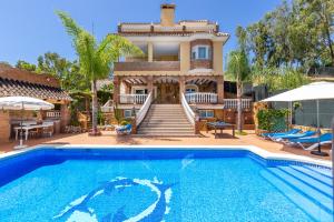 a house with a swimming pool in front of a house at Villa Trebol in Mijas