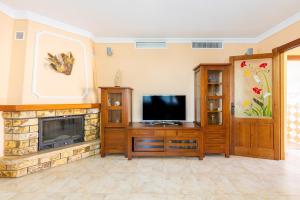 a living room with a television and a fireplace at Villa Trebol in Mijas