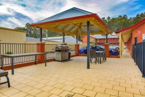 an outdoor area with a picnic table and a bench at Murray Waters Motor Inn & Apartments in Koondrook