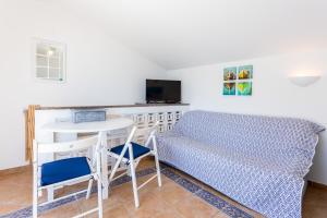 a bedroom with a bed and a desk and a table at Casa Pedro Burgau in Burgau