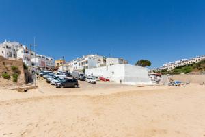 a group of cars parked in a parking lot on a beach at Casa Pedro Burgau in Burgau