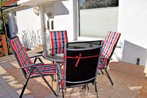 three chairs and a table on a patio at Ferienhaus an der Granitz in Seerams