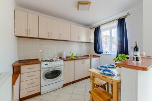 a kitchen with white cabinets and a dishwasher at Ambelia in Stegna