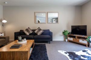 a living room with a couch and a tv at Lake Escape in Queenstown