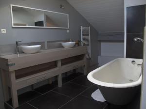 Chambres d'hôtes L'Epicurium في لو بوي: حمام مع مغسلتين وحوض استحمام