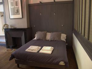 um quarto com uma cama com duas toalhas em Chambres d'hôtes L'Epicurium em Le Puy en Velay
