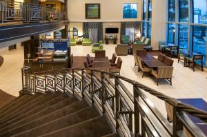 a staircase in a building with chairs and tables at Holiday Inn Express Hotel & Suites Houston North Intercontinental, an IHG Hotel in Houston
