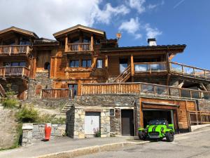 a green atv parked in front of a large wooden house at Chalet Opale in Tignes