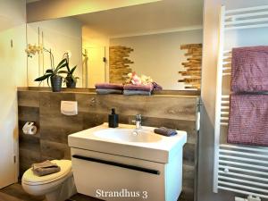Et badeværelse på Ferienwohnungen im Strandhus + 13 billeder