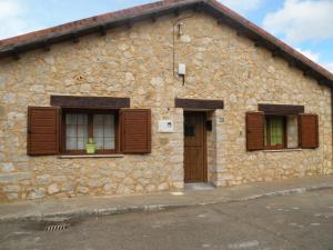 Casa Rural LAS ABUBILLAS في Mirabueno: مبنى حجري مع نافذتين وباب