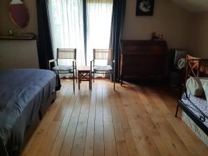 a bedroom with a bed and two chairs and a table at B&B Lomolen in Aalter