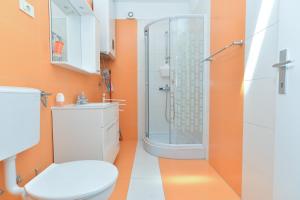 an orange bathroom with a toilet and a shower at Apartments Stana 242 in Fažana +63 photos