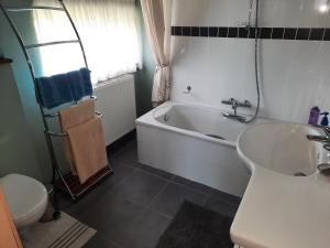 a bathroom with a tub and a sink and a toilet at B&B Lomolen in Aalter