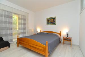 a bedroom with a wooden bed and a window at Apartments Stana 242 in Fažana