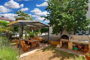 a picnic shelter with a picnic table and a grill at Apartments Stana 242 in Fažana