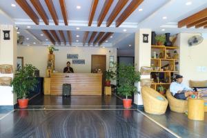 a lobby of a hotel with people sitting in chairs at Hotel Karuna in Pokhara