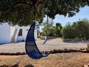 a blue hammock hanging from a tree in a yard at Hakuna matata in Benagil