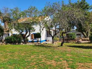 a white house with trees in a yard at Hakuna matata in Benagil
