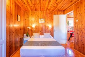 a bedroom with a large bed in a wooden wall at Les Bungalows des Makes in Makes