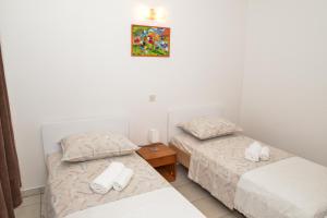 a bedroom with two beds and a picture on the wall at Apartments Lonić in Kukljica