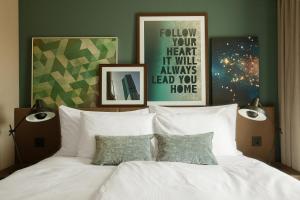 苏黎世Acasa Suites Zurich Oerlikon的卧室里有一张铺着白色床单的床和两盏灯