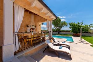 a patio with two lounge chairs and a swimming pool at Villa Rotonda in Vrsar