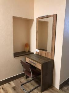 a wooden cabinet with a mirror on the wall at Bilyj Rojal in Zaporozhye