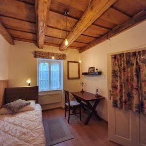 a bedroom with a bed and a desk and a window at Corte Apartman in Pápa
