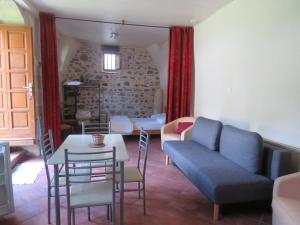 uma sala de estar com um sofá, uma mesa e cadeiras em Chez Bernard et Michèle em Manglieu